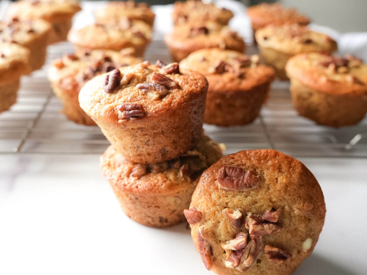 photo of stacked banana nut muffins and a tray of banana nut muffins