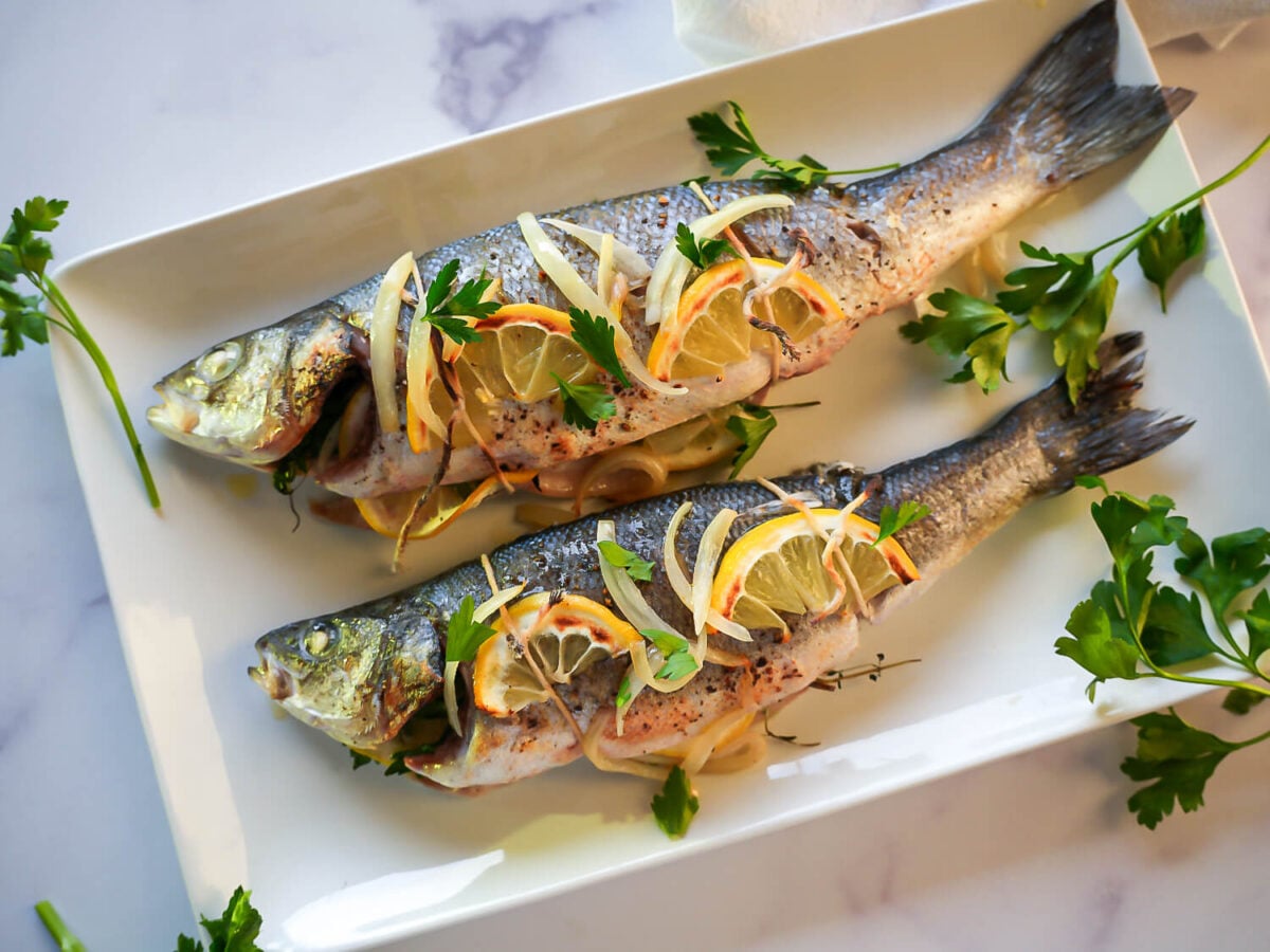 side view of Roasted Branzino on a white plate