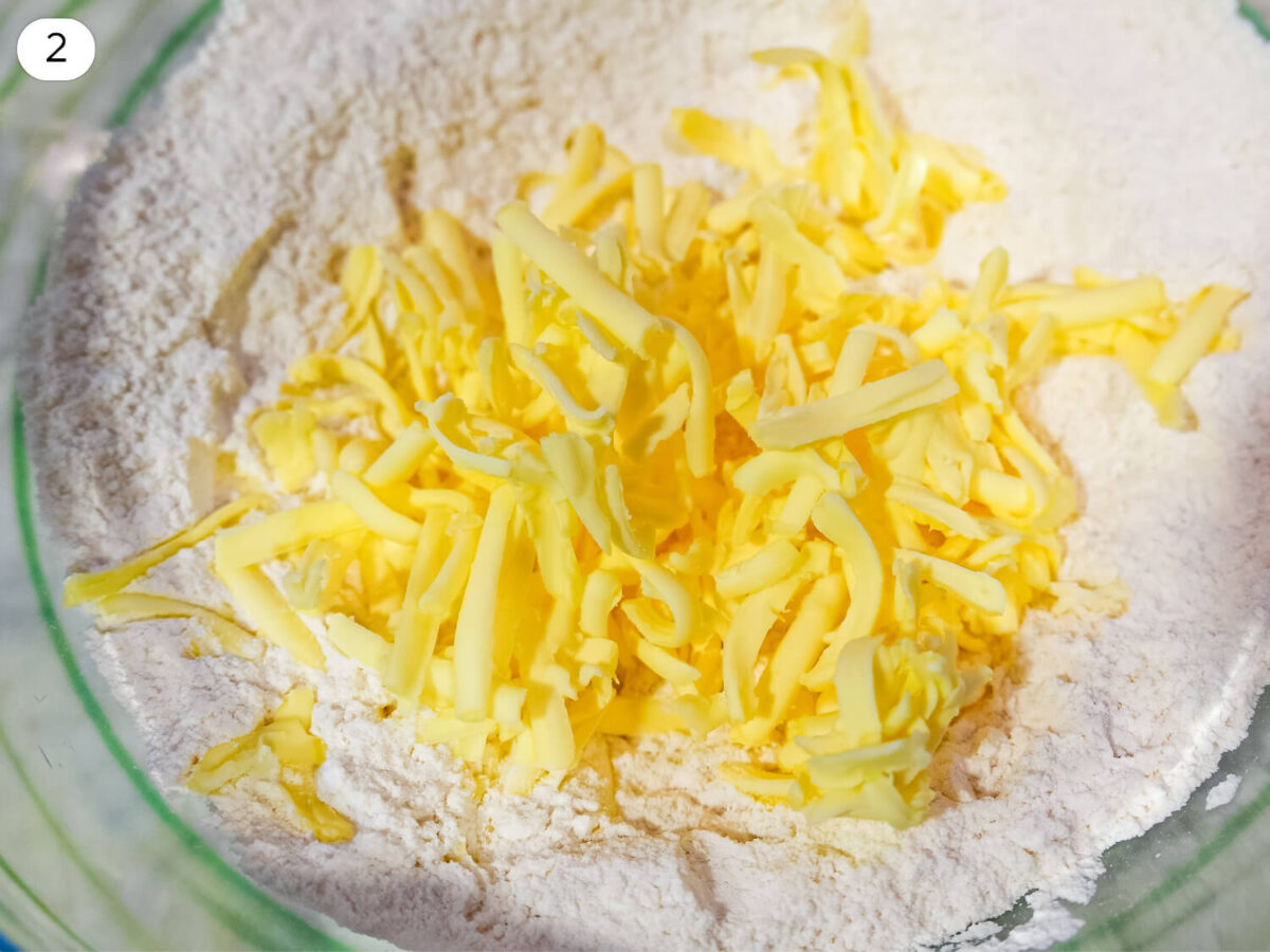 step 2 photo of cold shreds of butter being added to the dry ingredients