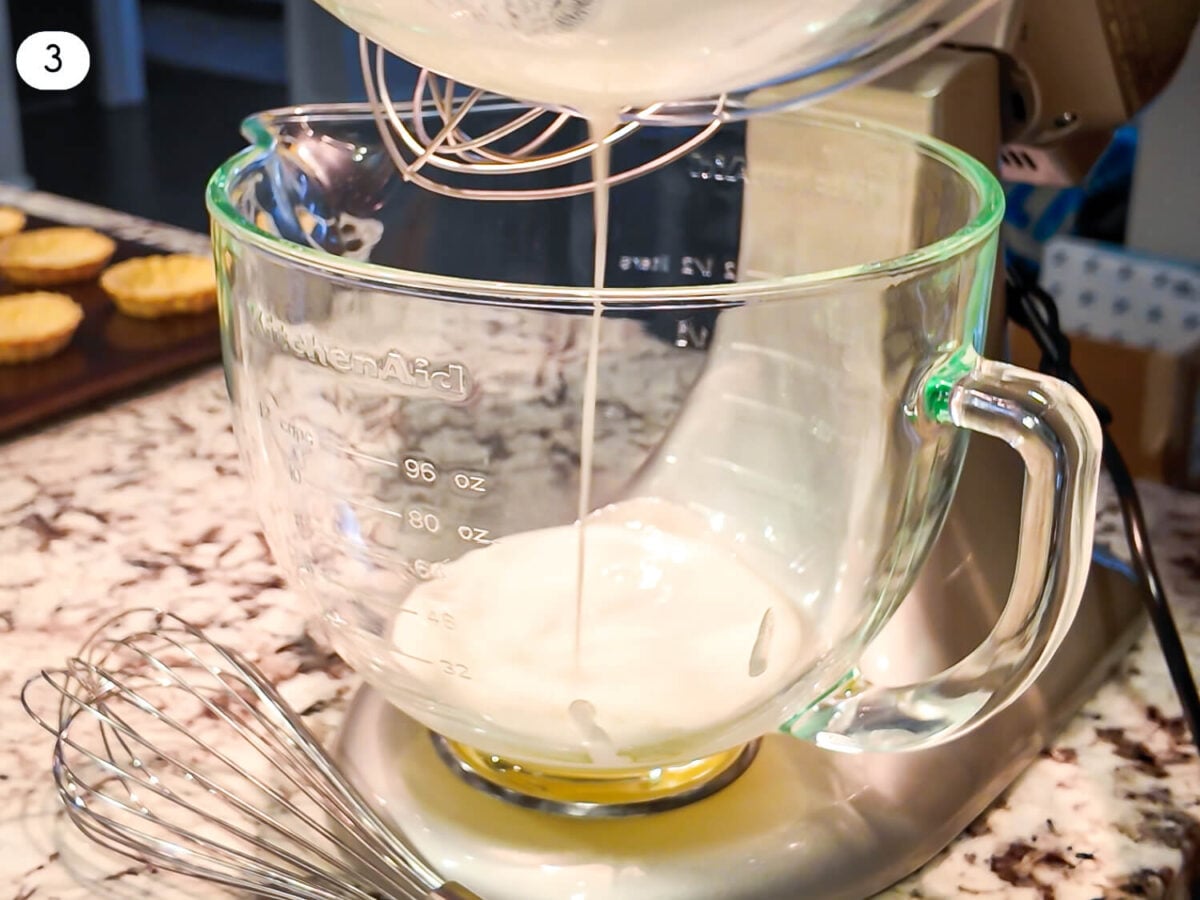 step three photo of Swiss Meringue being added to a mixing bowl
