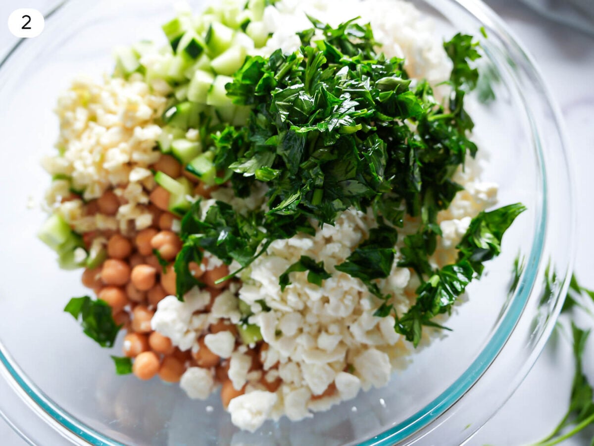 step two photo of Chickpea Cucumber Salad ingredients in a glass bowl