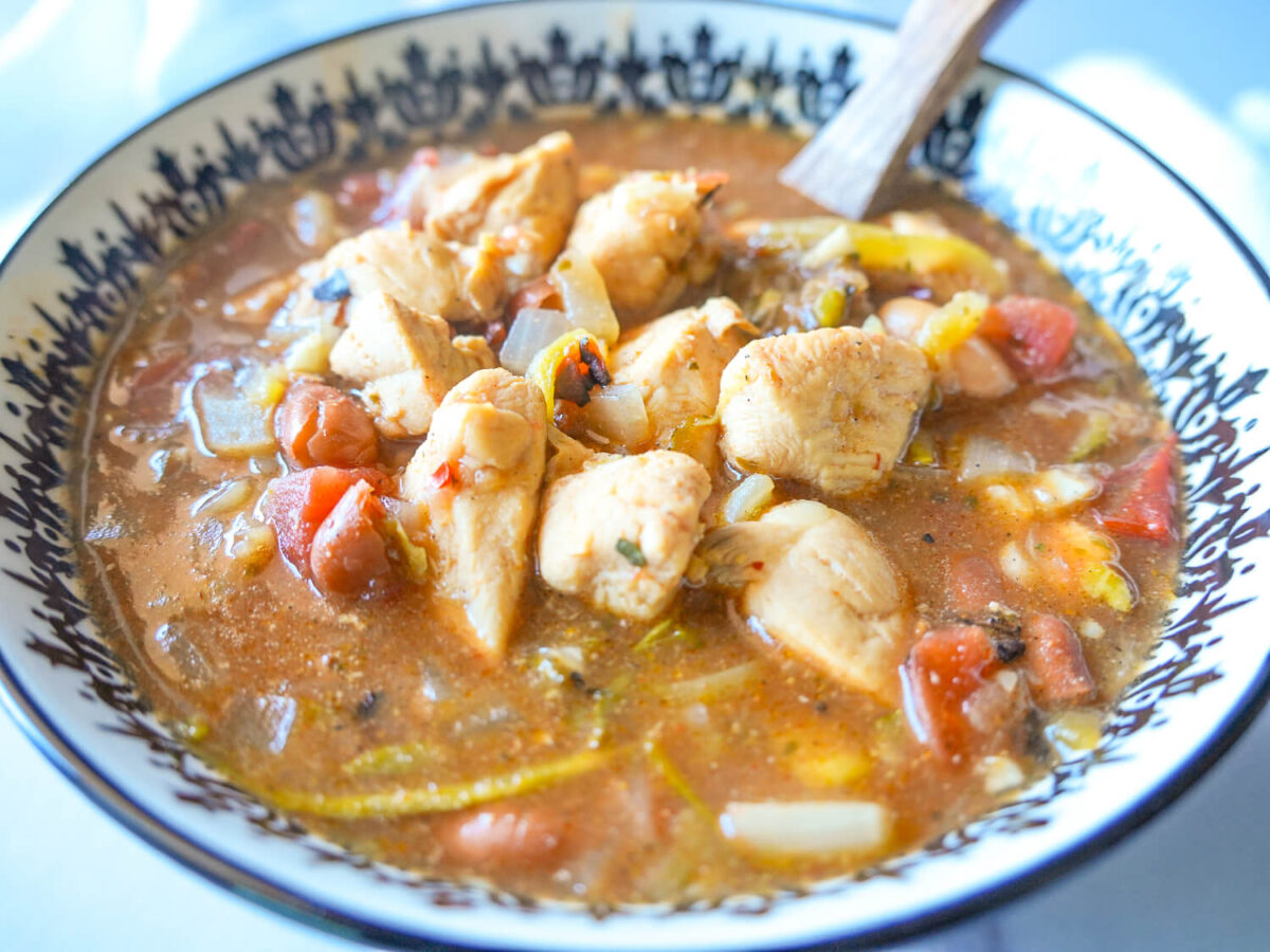 chicken chili in a bowl with a wooden spoon
