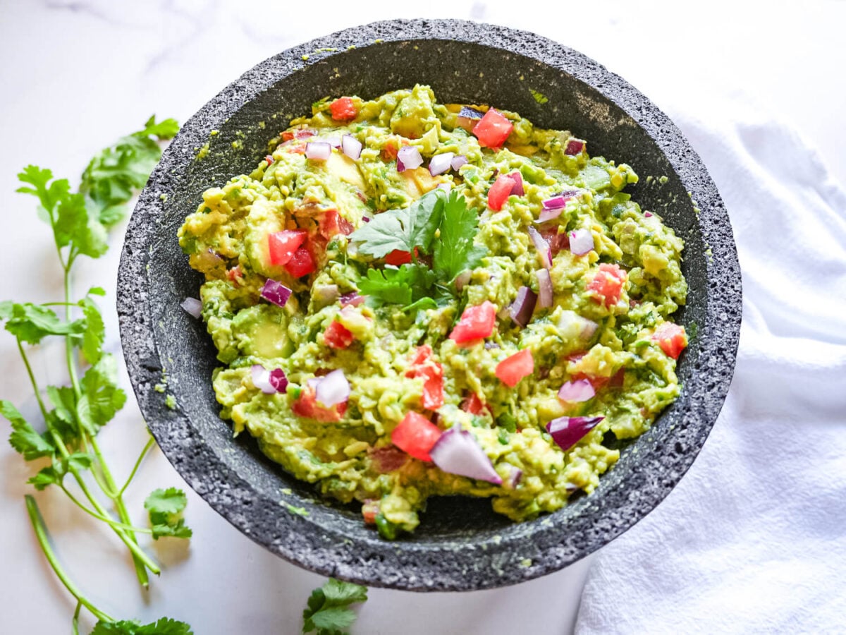 overhead photo of Guacamole with a cilantro leaf garnish on top