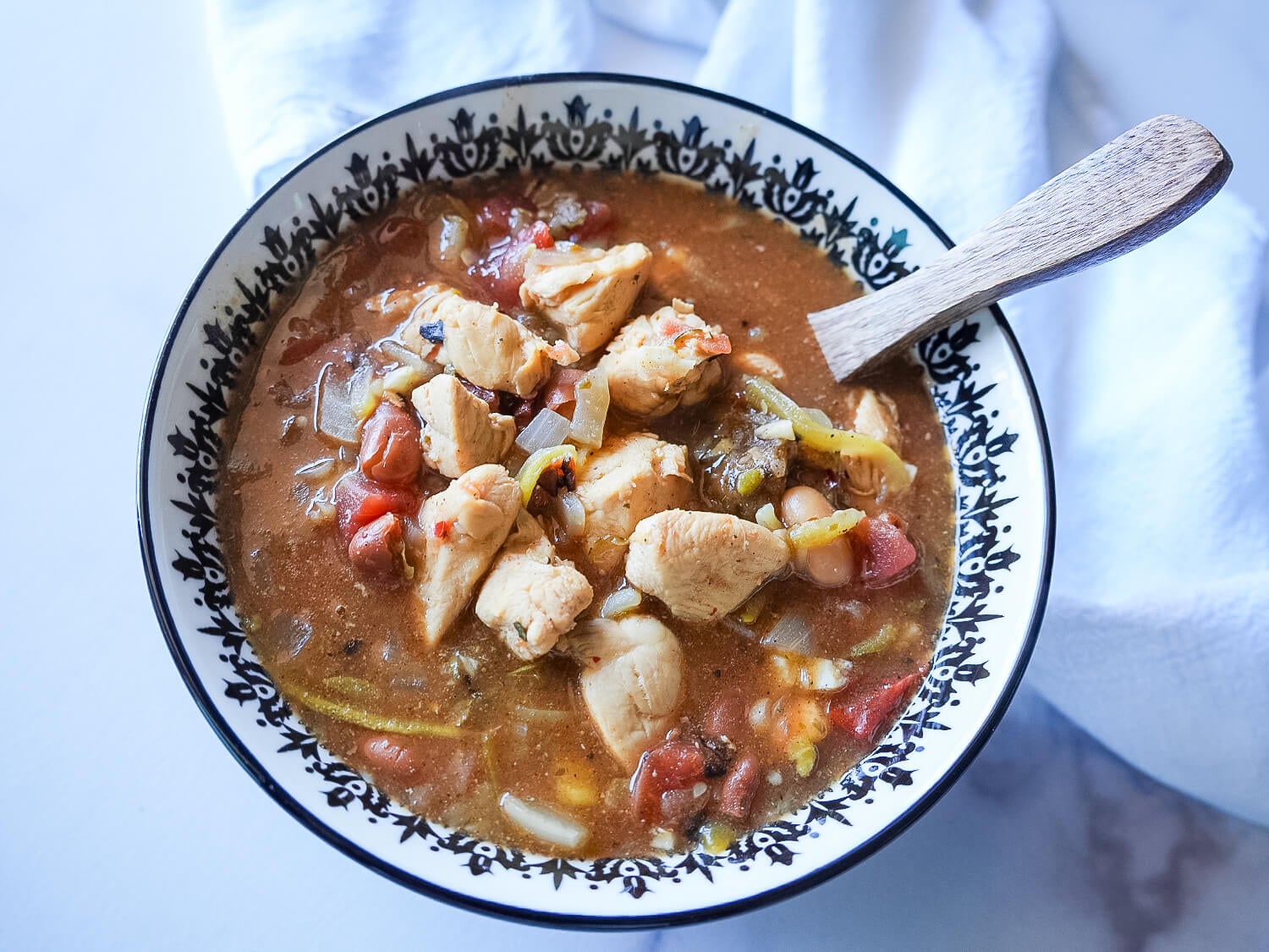 overhead photo of chicken chili in a black and white bowl