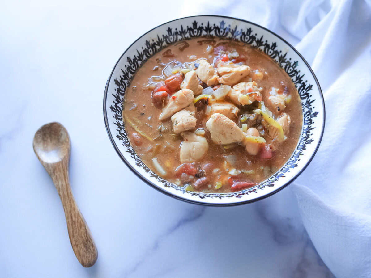 photo of chicken chili in a black and white bowl on a marble surface