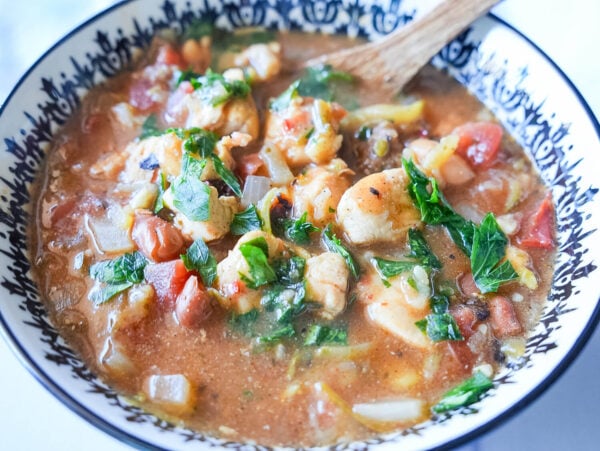 photo of chicken chili with parsley in a white and black bowl
