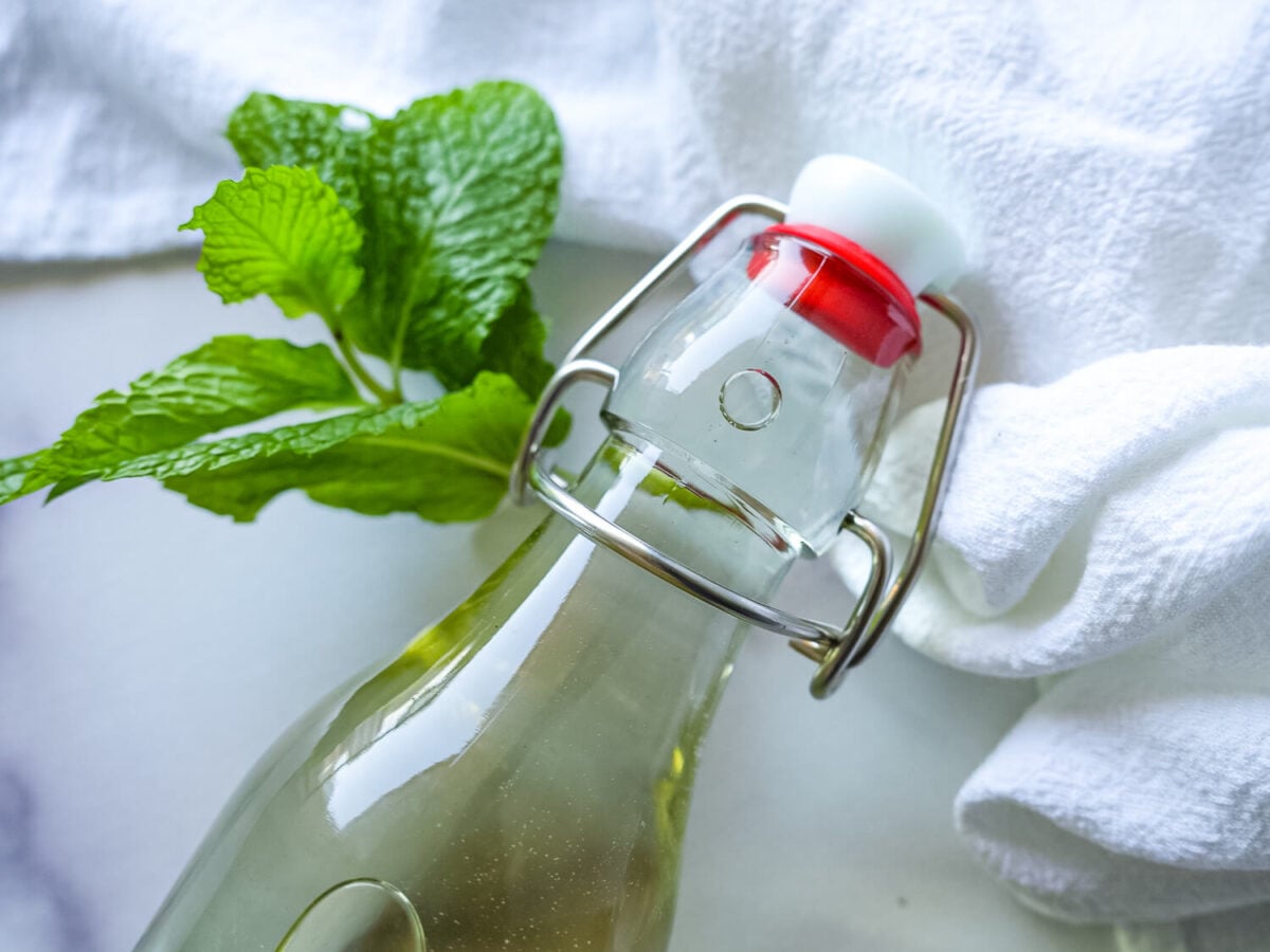 Close up photo of Mint Simple Syrup in an airtight container