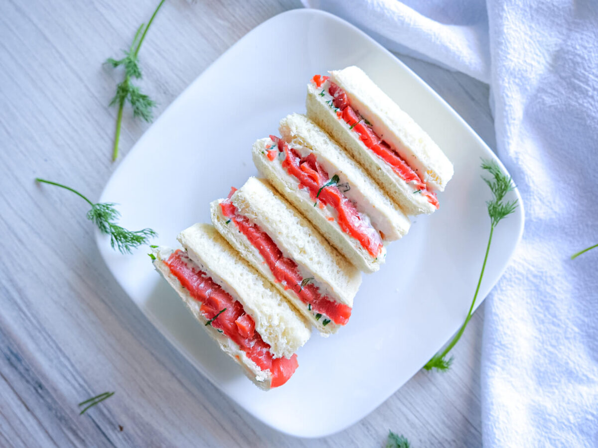Flatlay photo of Smoked Salmon Tea Sandwiches on a white plate