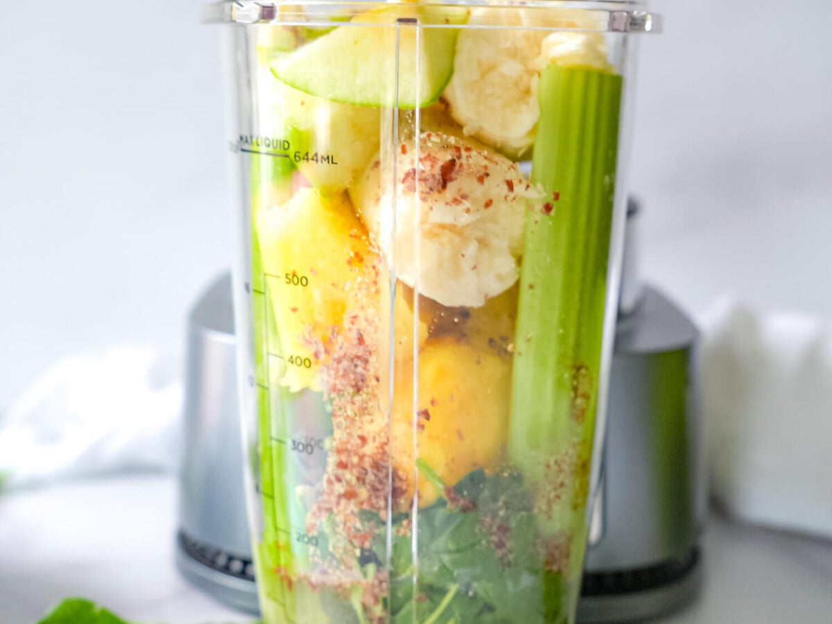 Photo of Pineapple Spinach Smoothie ingredients in a blender cup