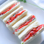 Side angle view of Smoked Salmon Tea Sandwiches on a platter
