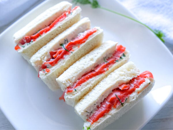 Side angle view of Smoked Salmon Tea Sandwiches on a platter