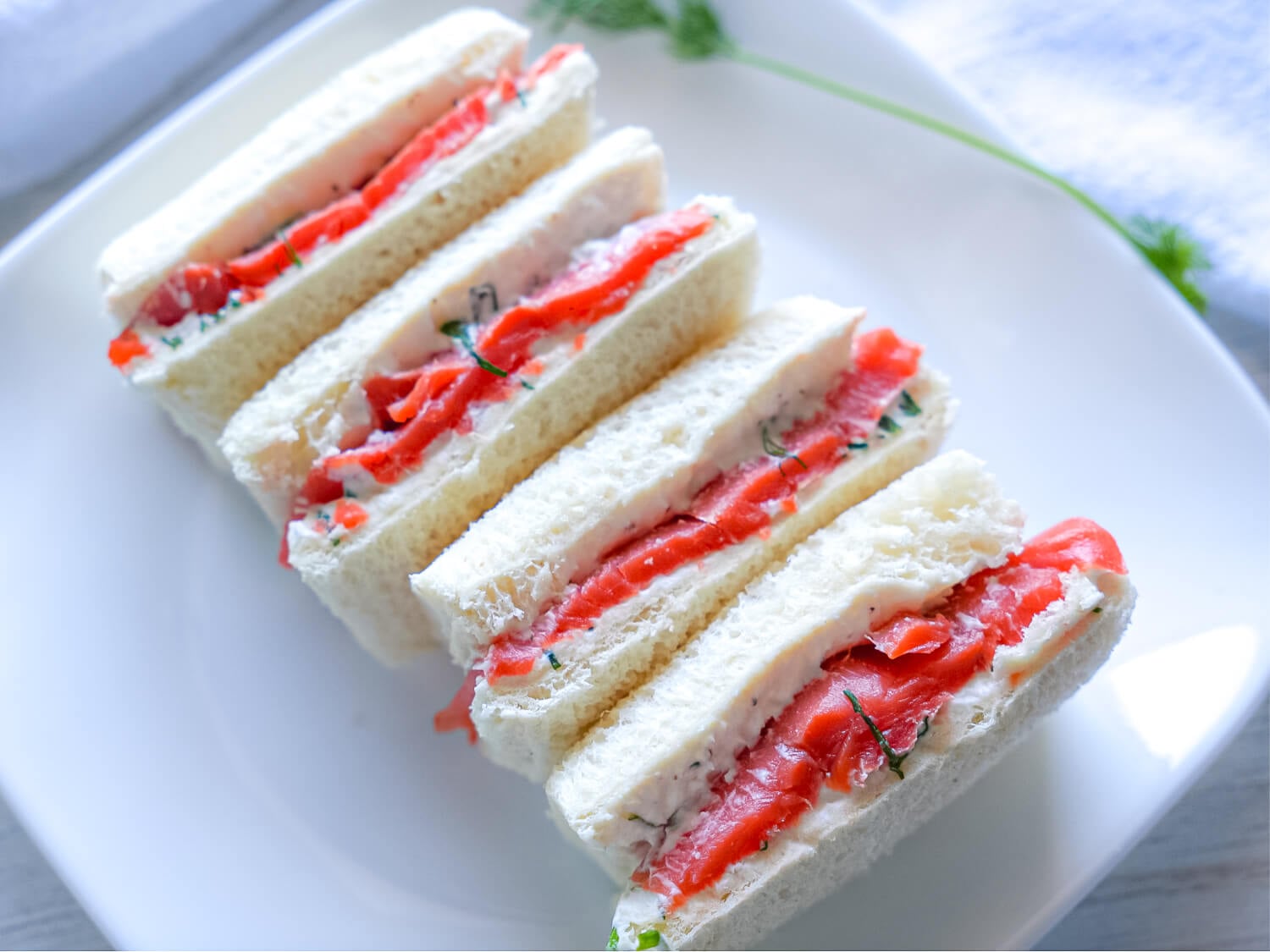 Side angle view of Smoked Salmon Tea Sandwiches on a platter