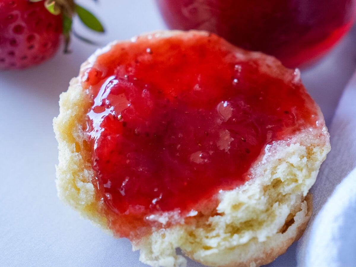 close up photo of strawberry jam on a biscuit