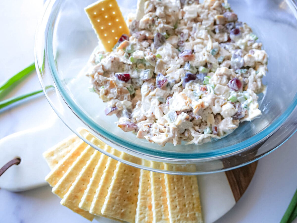 overhead photo of chicken salad in a glass bowl with crackers