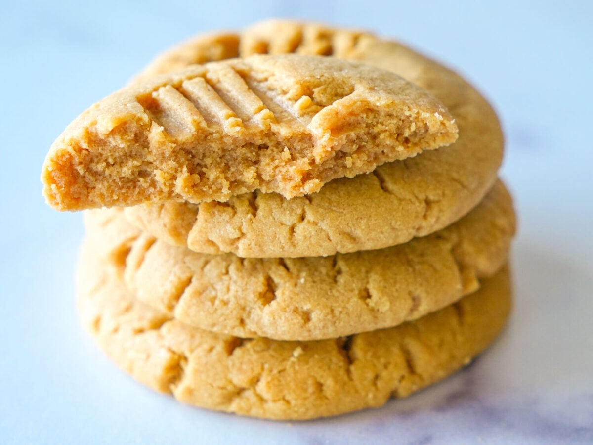 photo of 4 peanut butter cookies stacked with the top one broken in half