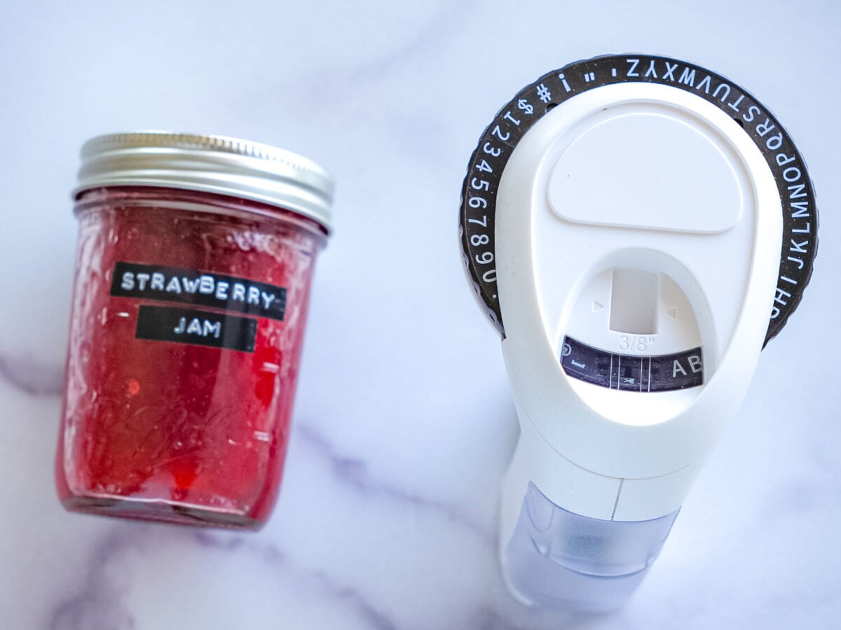 photo of a jar of strawberry jam next to a label maker