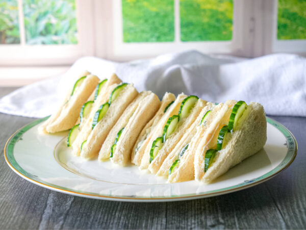 photo of cucumber sandwiches on a plate in front of a window
