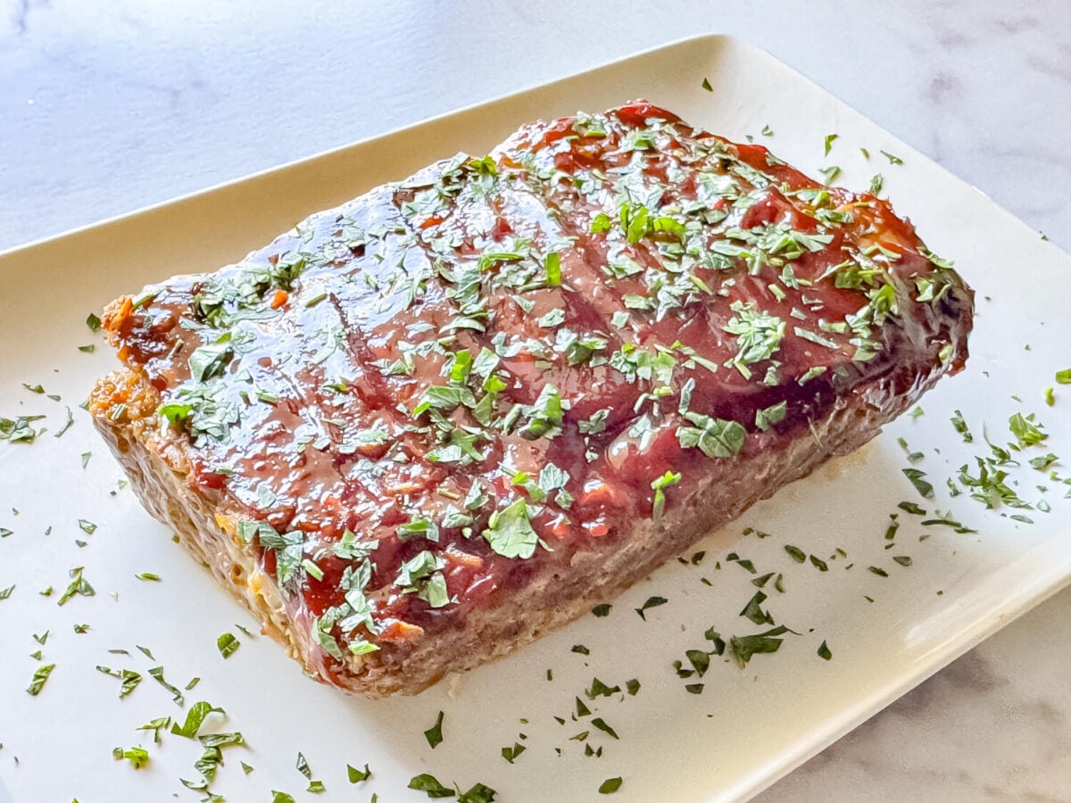 photo of meatloaf on a white tray with parsley garnished on top