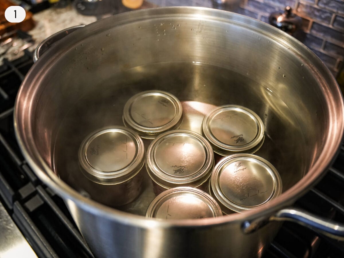 step 1 photo of sterilizing jars in a large pot