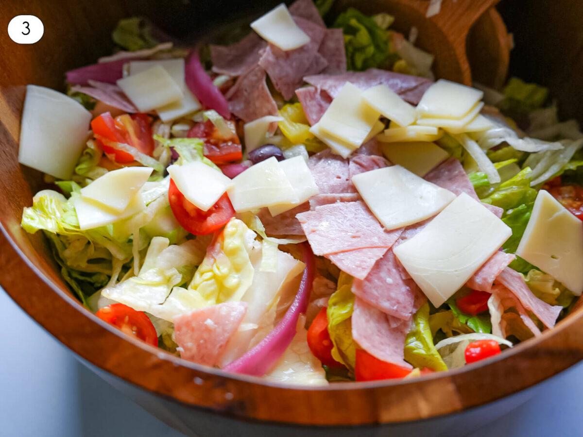 step 3 photo of adding salami and cheese to the salad bowl