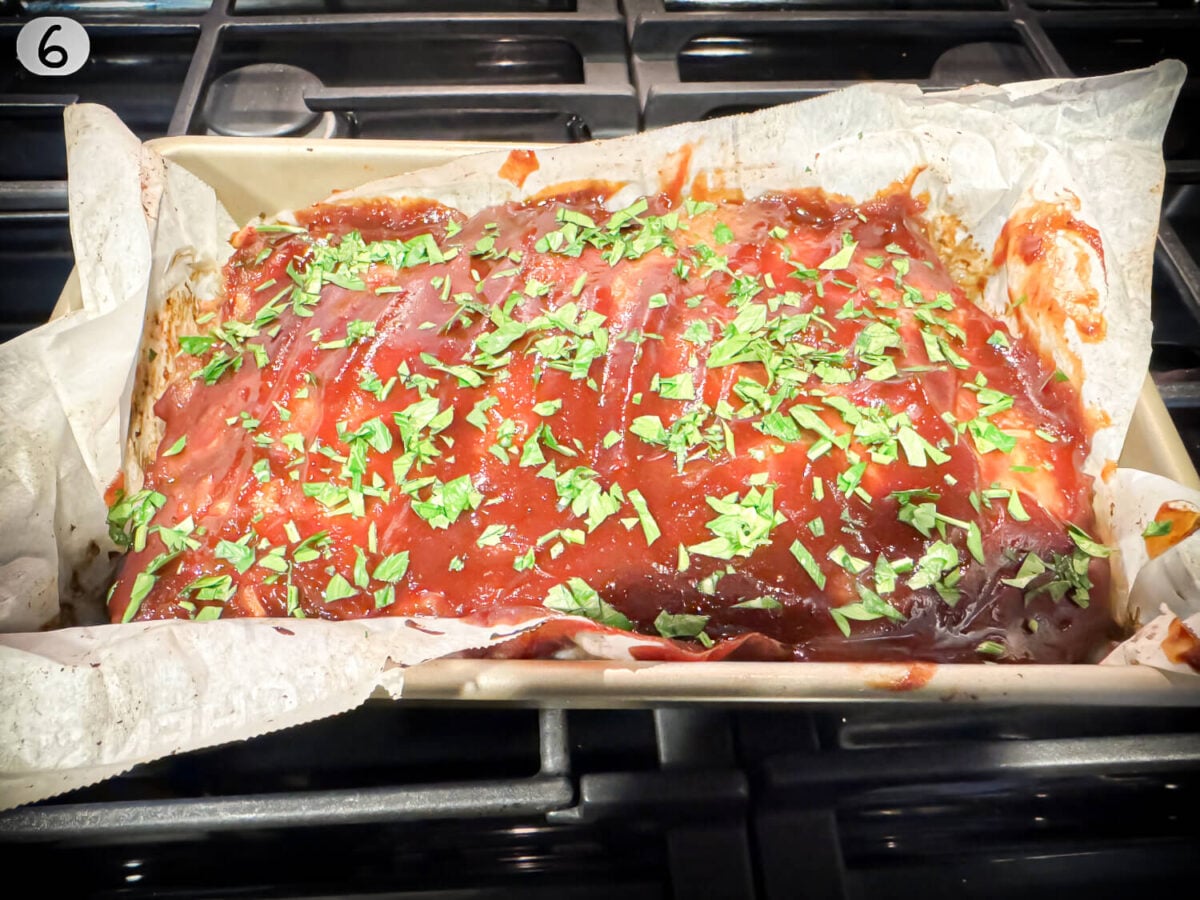 step 6 photo of baked meatloaf resting with parsley on top