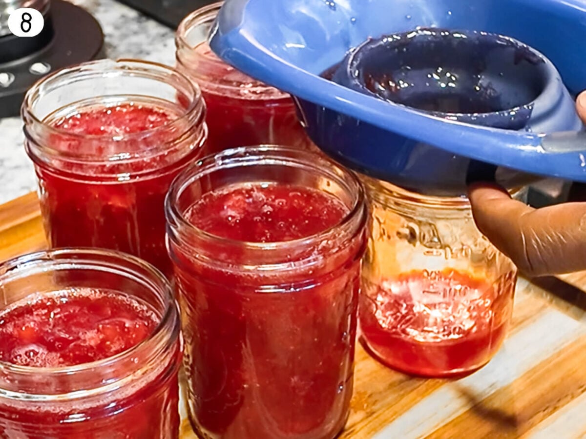 step 8 photo of strawberry jam being added to the mason jars