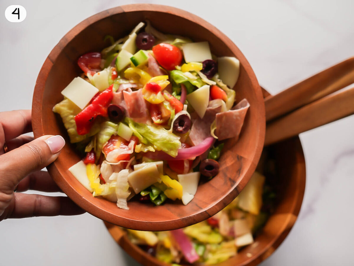 step four photo of tossing salad and placing in a serving bowl