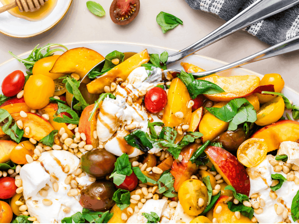 a photo of the Peach Burrata Salad with a fork and spoon