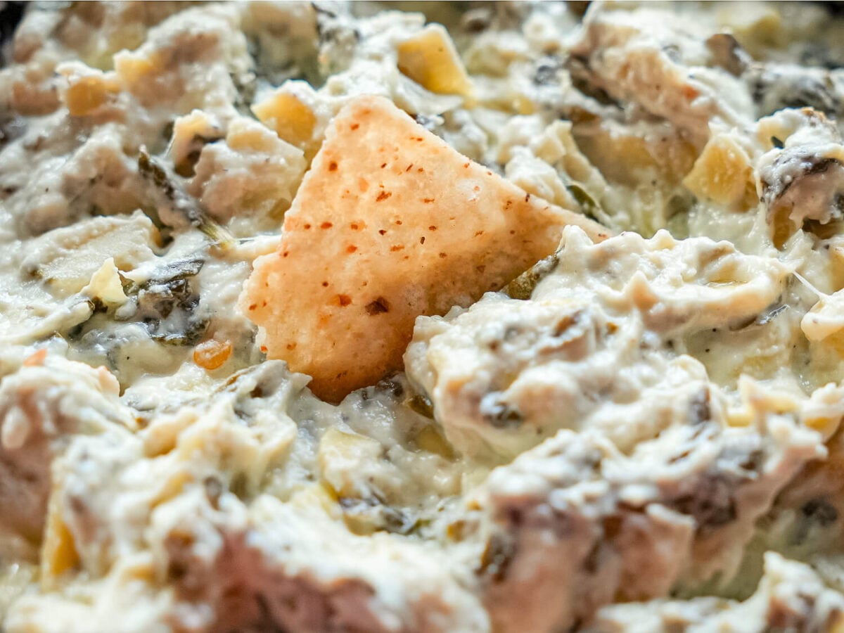 close up photo of Crockpot Spinach and Artichoke Dip with a chip