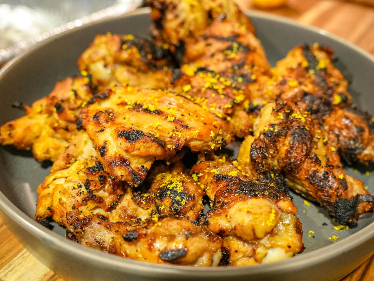 close up photo of grilled lemon chicken with lemon zest on it