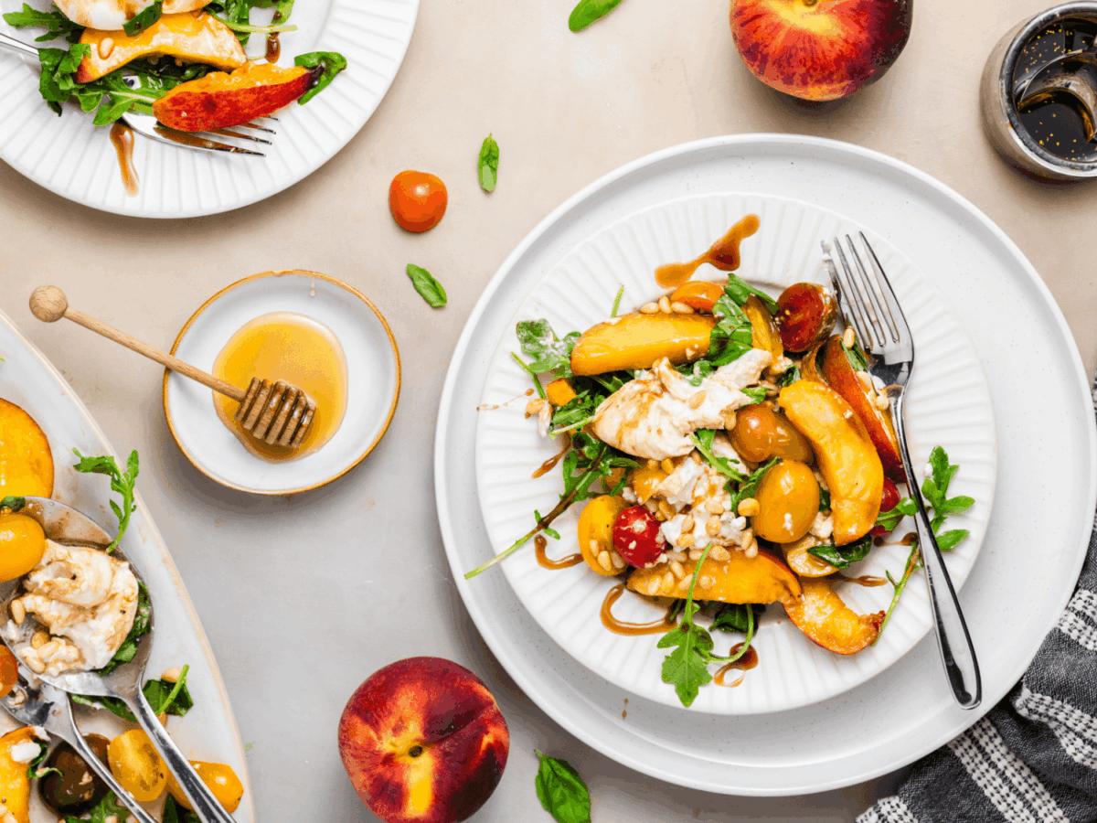 overhead photo of Peach Burrata Salad on a white plate