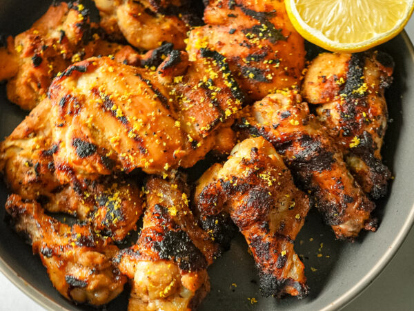overhead photo of grilled lemon chicken with a lemon slice