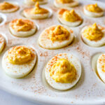 photo of Deviled Eggs on a white tray with paprika on top