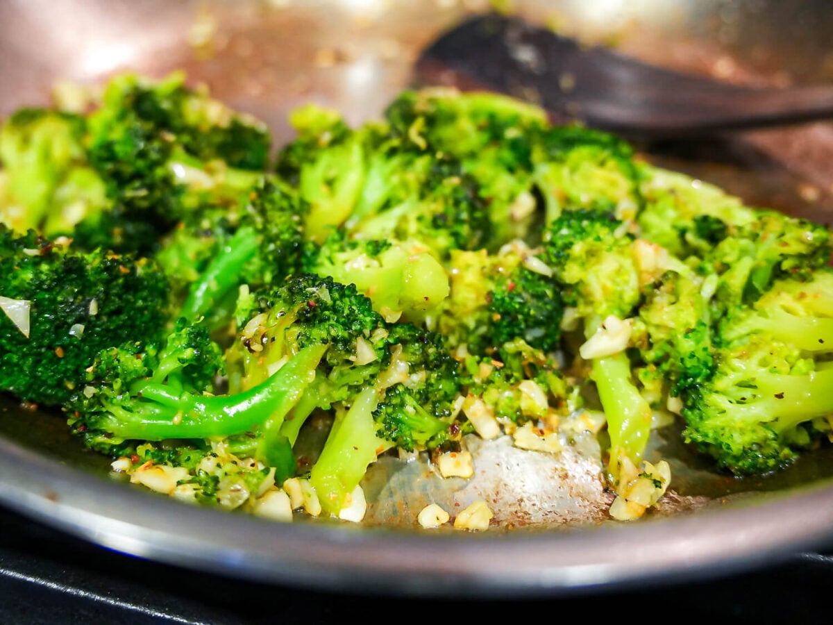 photo of Sautéed Broccoli in a pan with a wooden spoon