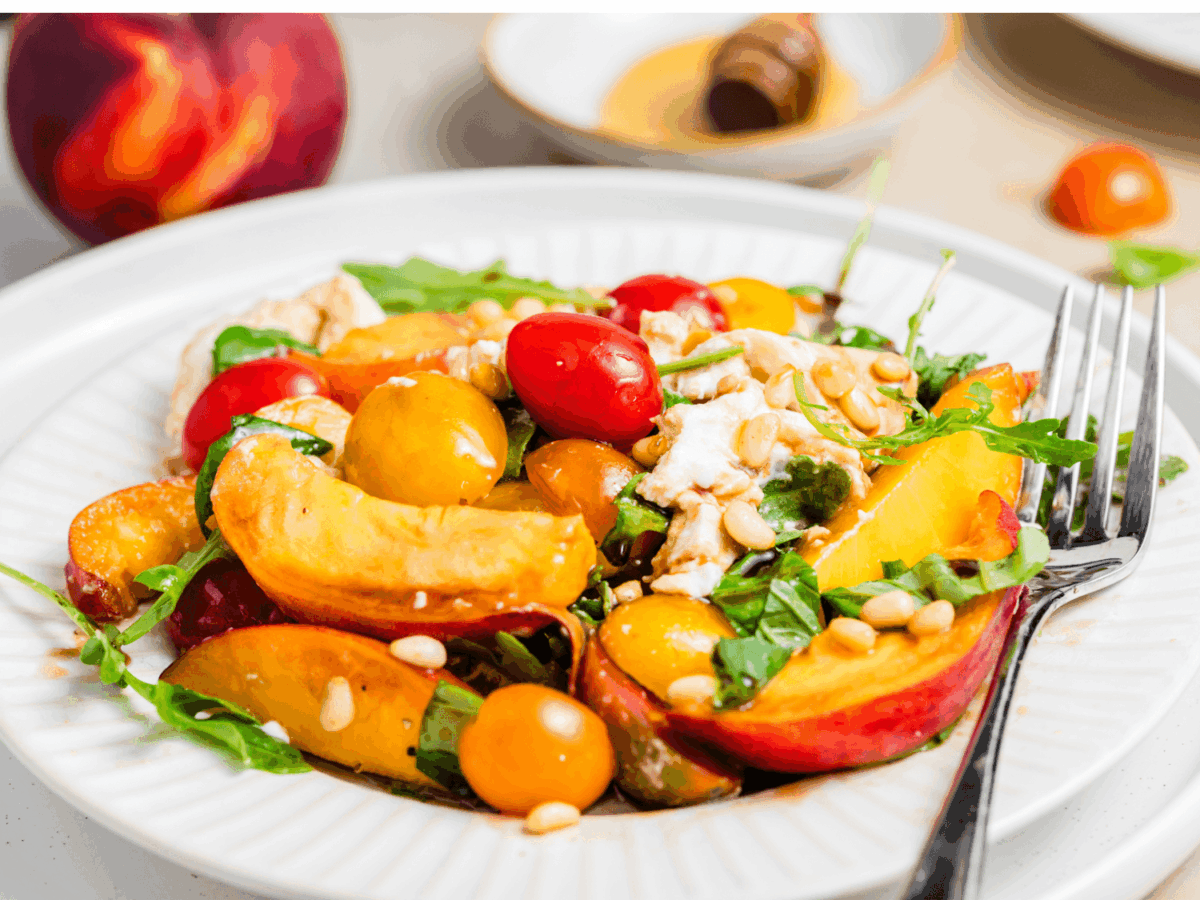 side photo of Peach Burrata Salad with a fork and white plate
