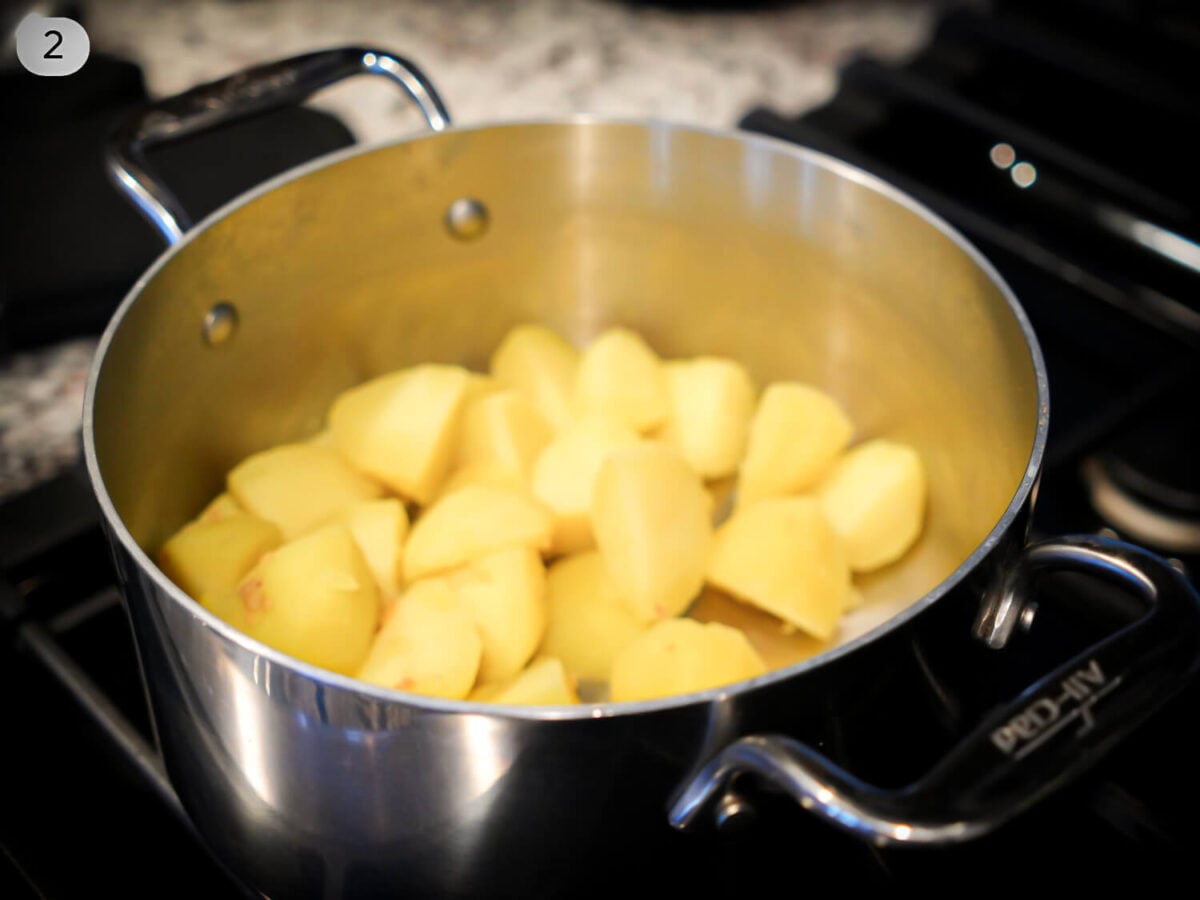 step 2 photo of potatoes steaming in a pot with the lid off-2