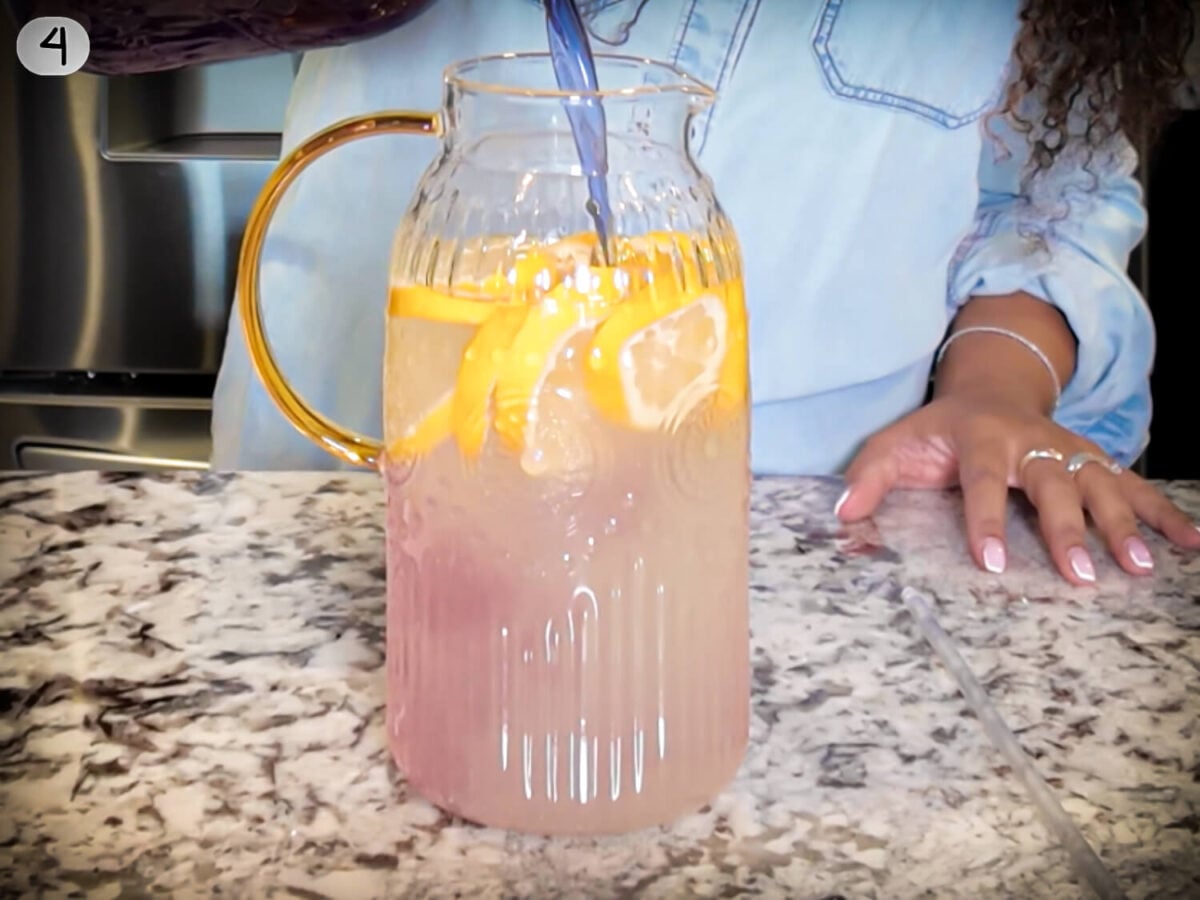 step 4 photo of lavender syrup being mixed into the lemon water before serving