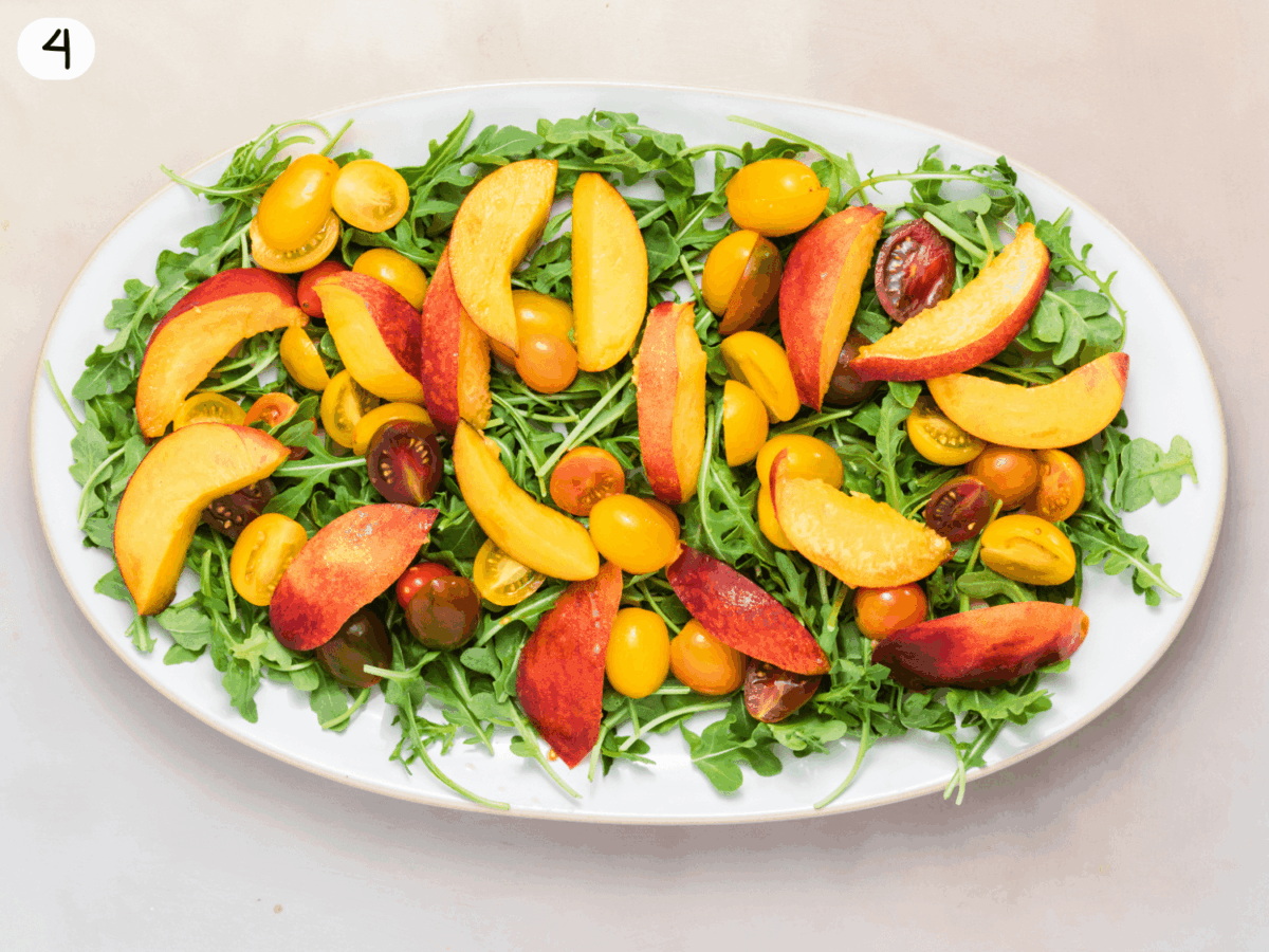 step 4 photo of peaches and tomatoes on a bed of arugula