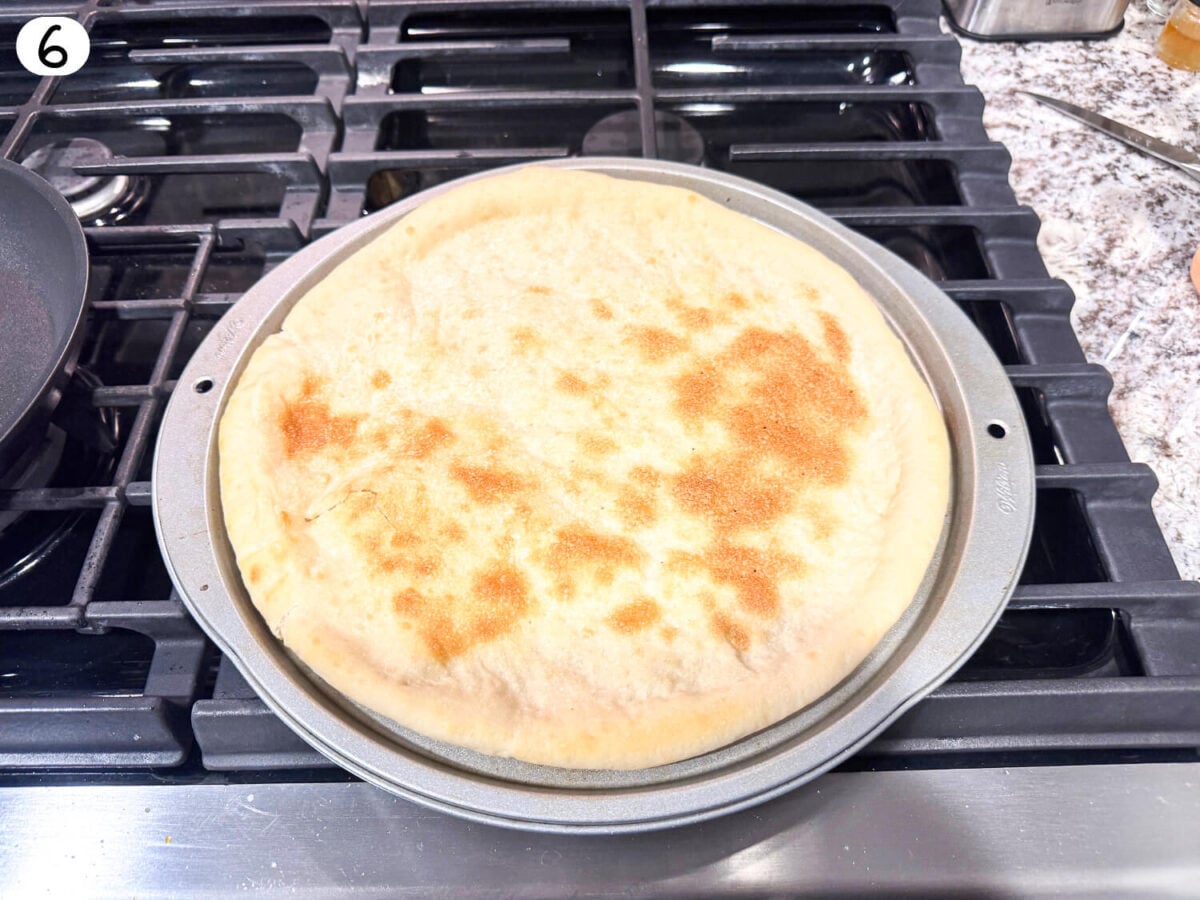 step 6 photo showing pizza being pre-baked