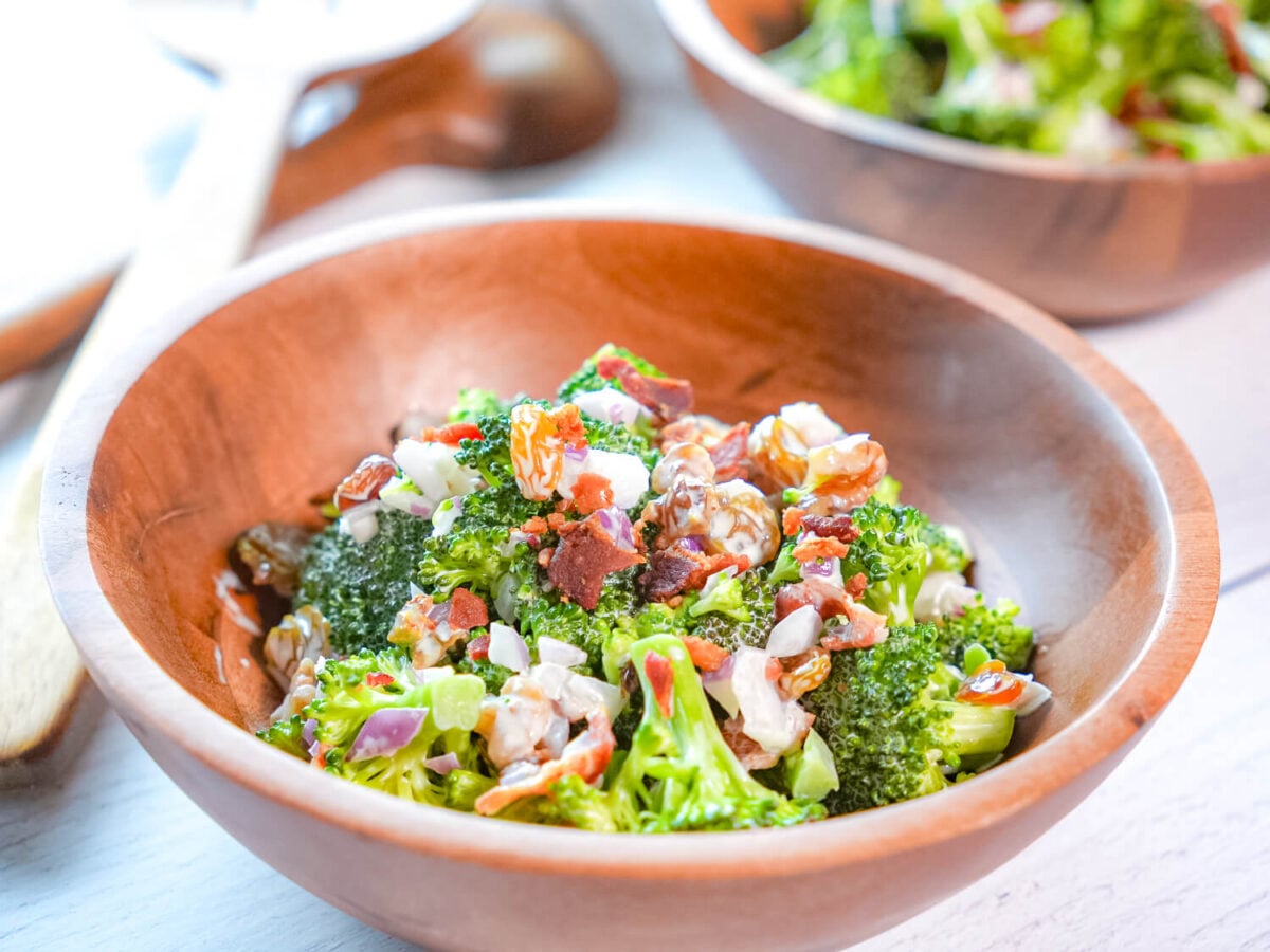 close up photo of broccoli salad with bacon in a wooden bowl
