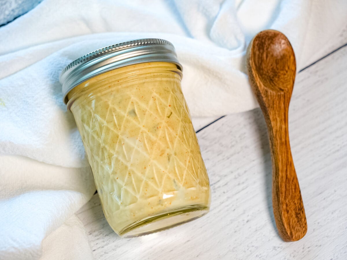 photo of Copycat Big Mac Sauce in a mason jar next to a wooden spoon