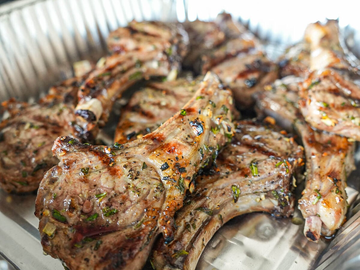 side photo of grilled lamb chops in a metal pan