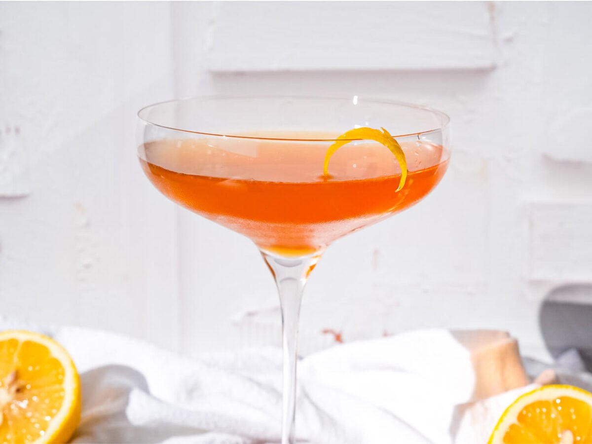 Front view of a Hennessy Sidecar cocktail front of a white wall