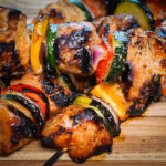 HERO Grilled chicken kabobs on a wooden cutting board