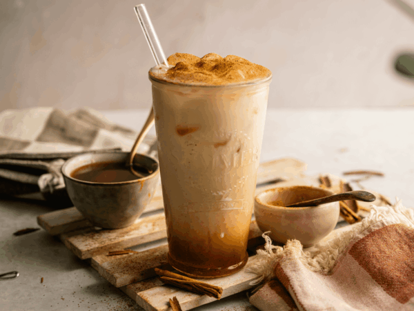 HERO of Iced Pumpkin Cream Chai with syrup in the background