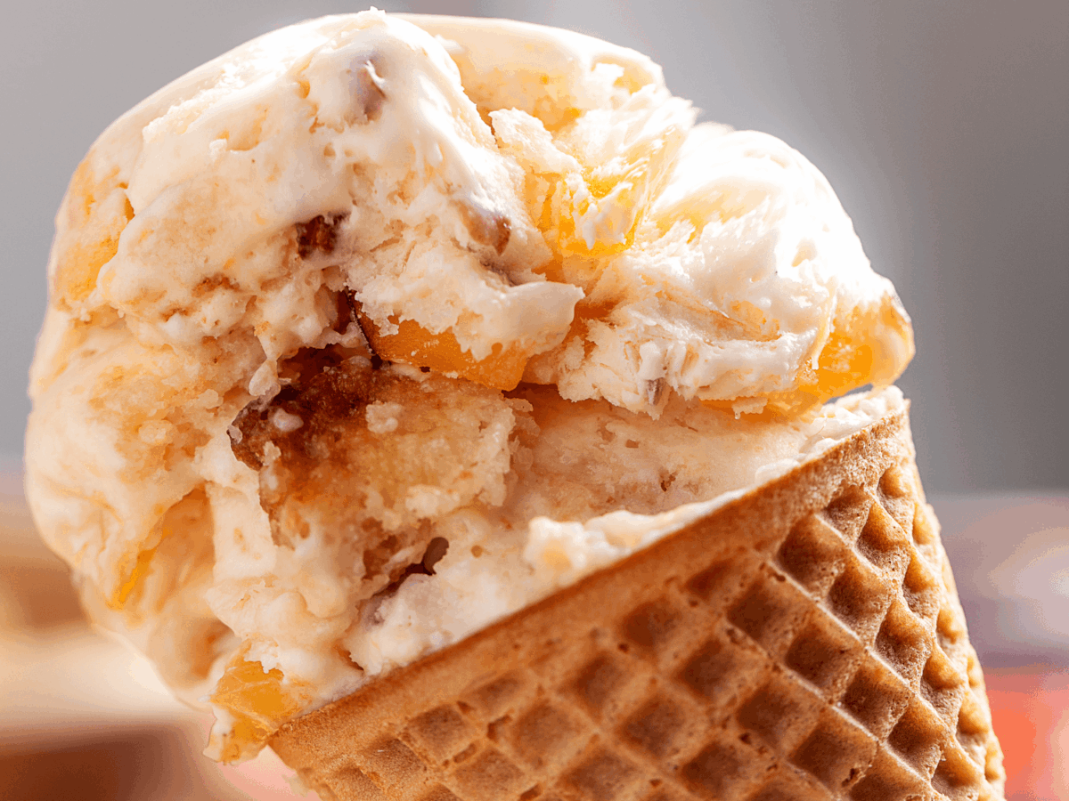 close up photo of peach cobbler Ice Cream on a cone