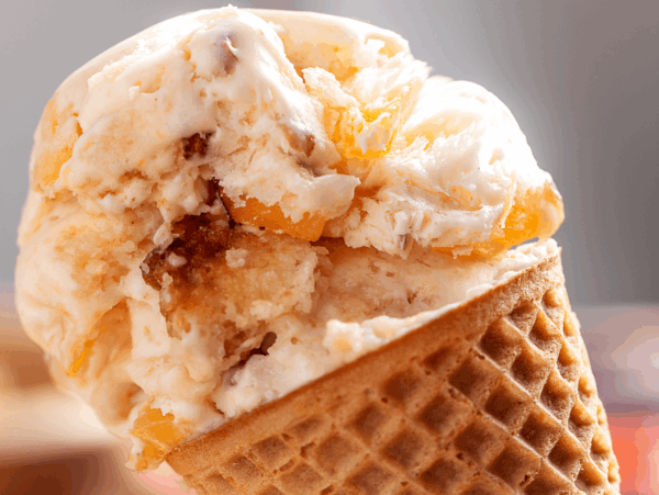 close up photo of peach cobbler Ice Cream on a cone