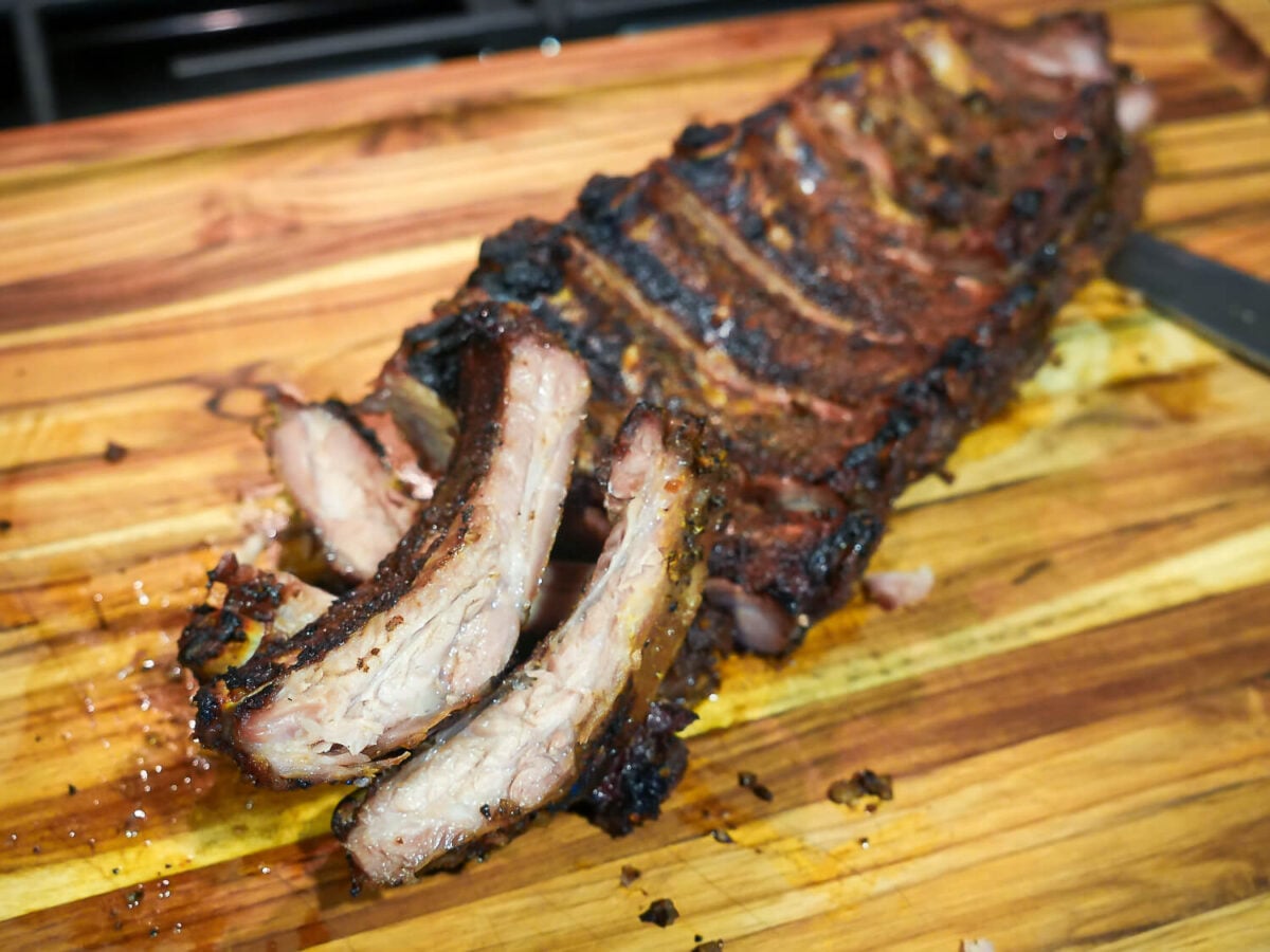 Photo of BBQ Baby Back Ribs that are cut and resting on a wooden cutting board