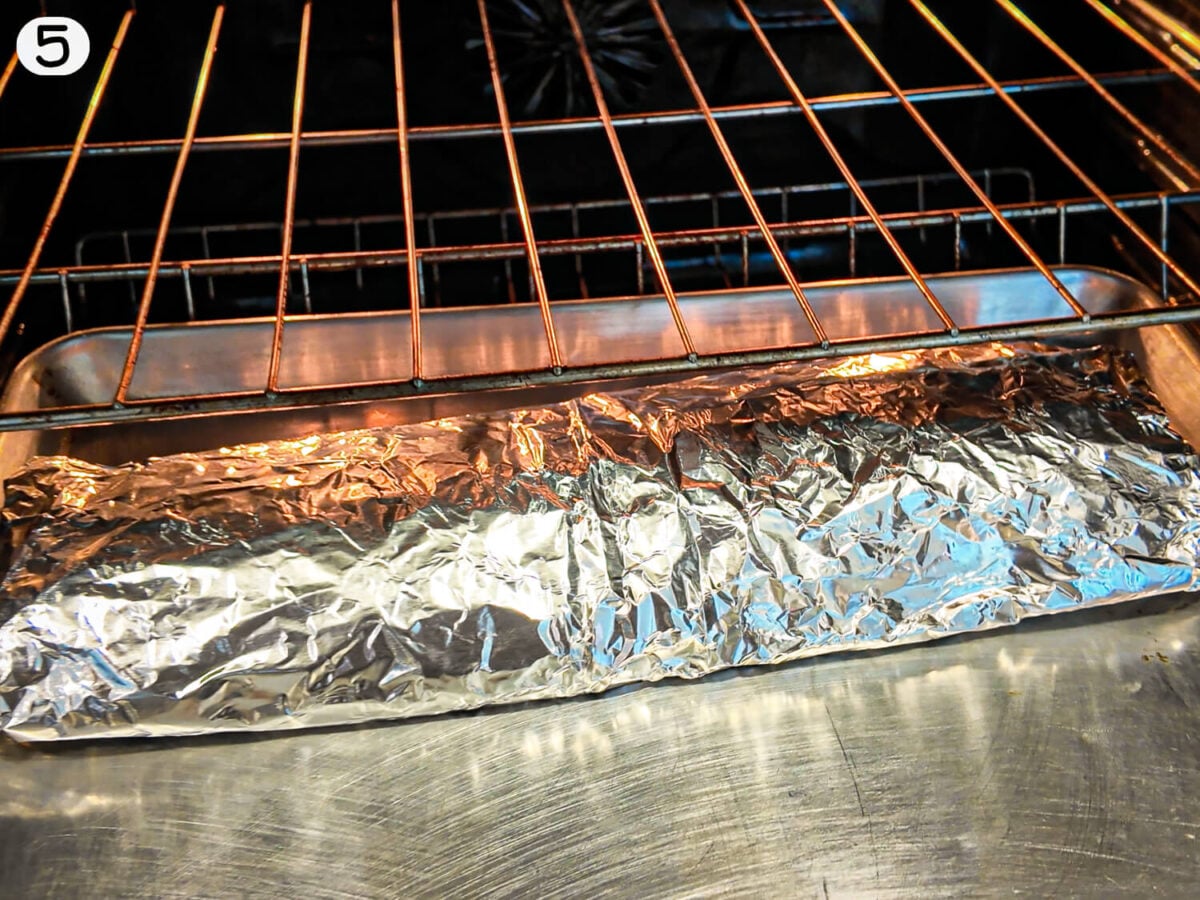 STEP 5 photo showing the ribs being baked in the oven low and slow