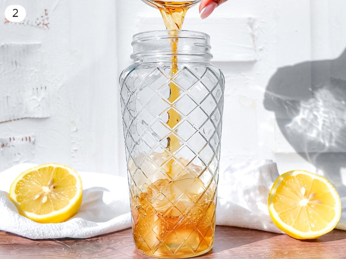 Step 2 photo showing Hennessy being poured into a cocktail shaker filled with Ice